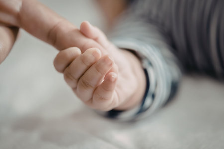 A close-up view of two hands clasped together, conveying a sense of support, care, and connection.