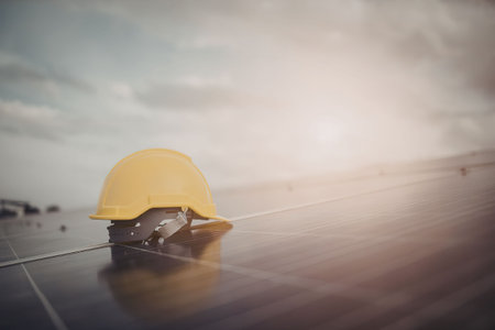 A yellow safety helmet on a solar panel with the sun setting in the background