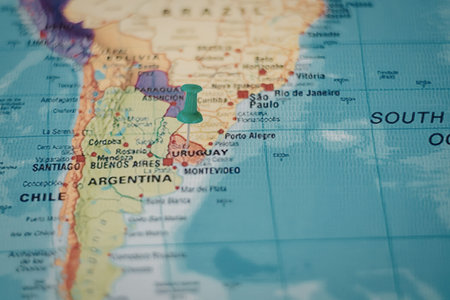 A close-up view of a map of South America with a green marker on Argentinaの写真素材