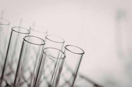 A close-up view of clear glass test tubes arranged in a rack, set against a white background.