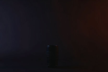 A dark room with a single can in the center, lit by a faint light source.