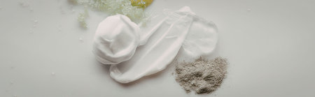 The image shows a small pile of various white and green powders and substances on a plain surface.