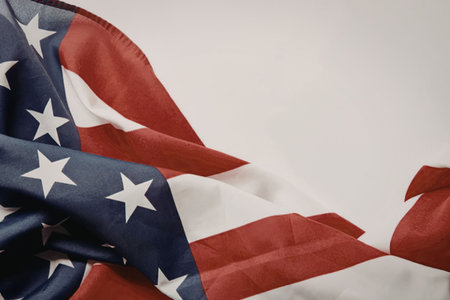 A close-up view of the American flag waving with its iconic red and white stripes and blue rectangle...