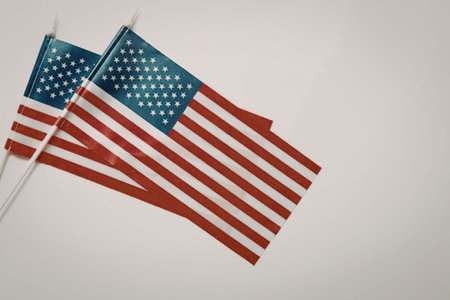 Two small American flags waving on white background