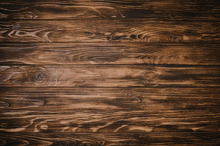 A close-up image of brown wooden planks with a prominent grain texture, showcasing the natural...