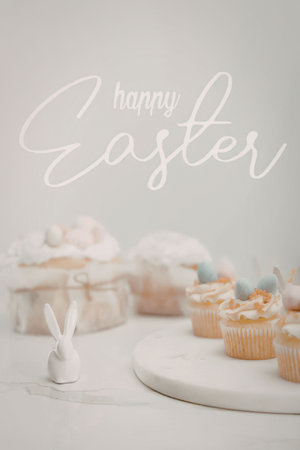 Easter celebration with cupcakes, bunny and cake on white background