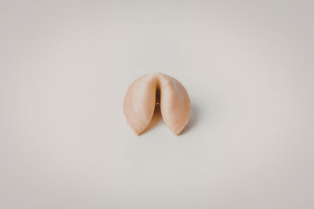 A single fortune cookie on a plain white background, split open to reveal nothing inside.