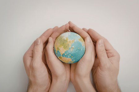 A pair of hands gently holding a small globe, symbolizing protection and care for the Earth.
