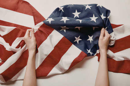 A person's hands tearing an American flag, symbolizing distress or protest.