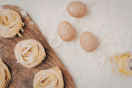A wooden board with pastry desserts and eggs on a flour-covered surfaceの写真素材