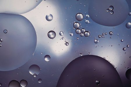An image of various sized bubbles floating in water, with a gradient of light to dark hues.