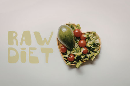 A heart-shaped plate of fresh vegetables and fruits representing a raw diet