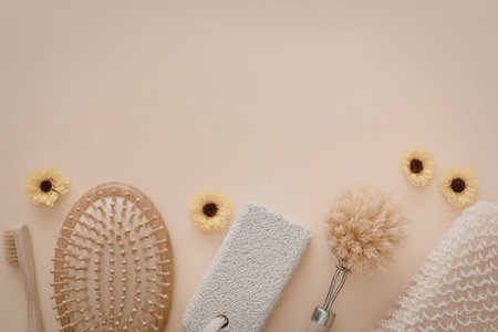 An arrangement of natural skincare tools and flowers on a beige background
