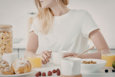 a woman sitting at a table with a variety of breakfast foods