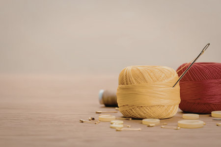 Two colorful yarn balls, one yellow and one red, accompanied by a crochet needle and scattered...