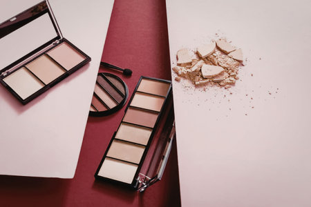 The image displays various makeup products on a pink background, including eyeshadow palettes and a...