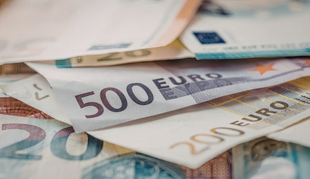 Euro banknotes scattered and overlapped in a pile showcasing various euro denominations including...