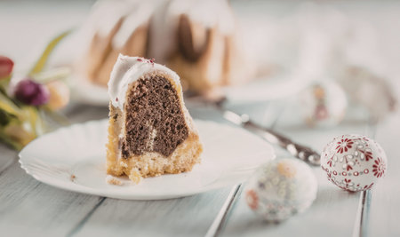 Delicious slice of chocolate babka cake on a white plate beautifully presented with floral...