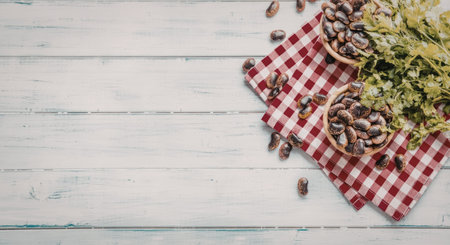 Freshly harvested beans in bowls with parsley on a red and white checkered cloth on a white wooden...