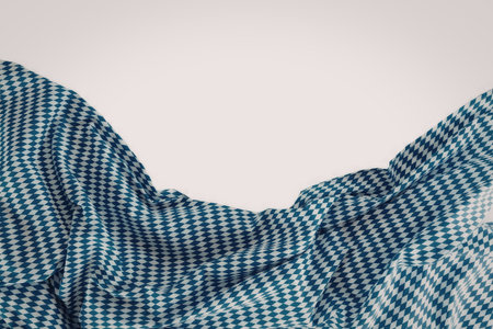 Blue and white houndstooth fabric flows freely showcasing a classic diamond pattern against a clean...