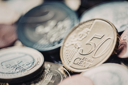 Fifty euro cent coin prominently displayed among various euro coins in different denominations and...