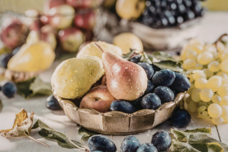 Fresh assorted fruits including grapes, plums, and pears are arranged in a bowl on a table with...