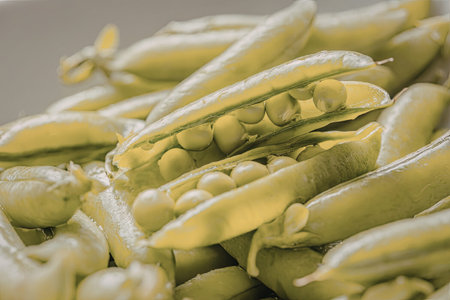 Fresh green peas in pods with water droplets on them, symbolizing healthy eating and organic...