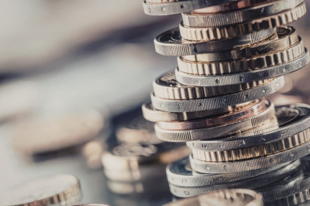 Stacked coins are precariously balanced on top of each other symbolizing financial stability and...
