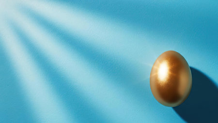 A shiny golden egg resting on a blue surface with light rays shining on it.