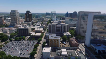 A vibrant cityscape showing tall buildings, streets, and urban life in daylight.