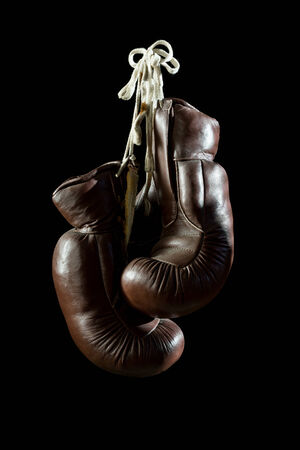 old Boxing Gloves, hanging, isolated on black Backgroundの写真素材