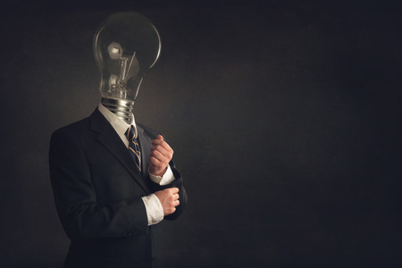 Smart businessman in Suit with a light bulb as headの写真素材