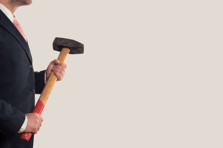 A Businessman holding a sledgehammer in his handsの写真素材
