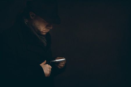 a Man with a razor is waiting in the darkの写真素材