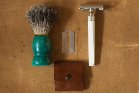 Flat Lay of Shaving Equipment on wooden Table and vintage Backdrop
