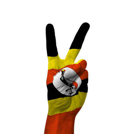 Hand making victory sign, uganda painted with flag as symbol of victory, win, success - isolated on white backgroundの写真素材