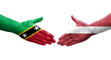 Handshake between Latvia and Saint Kitts and Nevis flags painted on hands, isolated transparent image.の写真素材