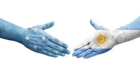 Handshake between Micronesia and Argentina flags painted on hands, isolated transparent image.の写真素材