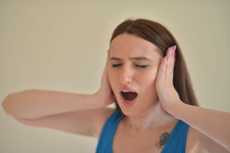 A girl disturbed by noise, covering her ears.の写真素材