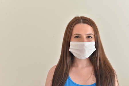 Girl is wearing mask aganist covid-19. Photograph with an emty space left.の写真素材