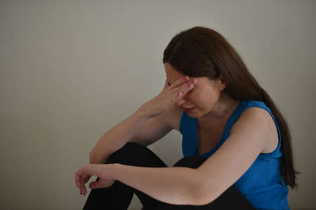Sad girl, crying, sitting on the floor.の写真素材