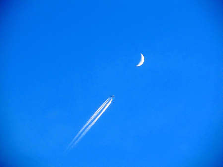 Moon and airplane on sunset sky beautifullyの写真素材