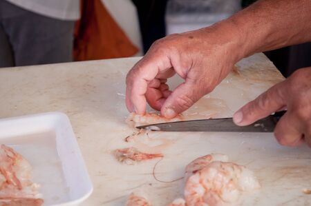 Close of a fisherman cleaning shrimpの写真素材
