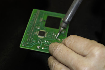 Woman welding a eletronic board  Focus on hand 