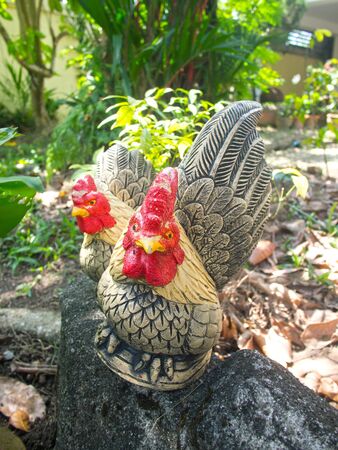 two ceramic rooster in gardenの写真素材