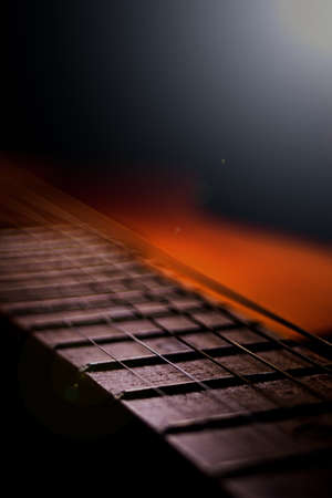 Classical guitar with metal strings in the light of lampsの写真素材