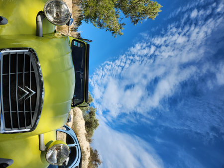 Yellow truck on a background of blue sky with white clouds.の写真素材