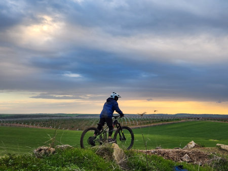 Silhouette of a cyclist riding a mountain bike in the countrysideの写真素材