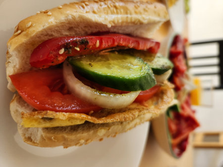 Sandwich with tomato, cucumber and onion on a plate.の写真素材