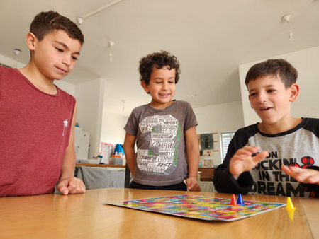 Group of kids playing board game at home. Children having fun together.の写真素材
